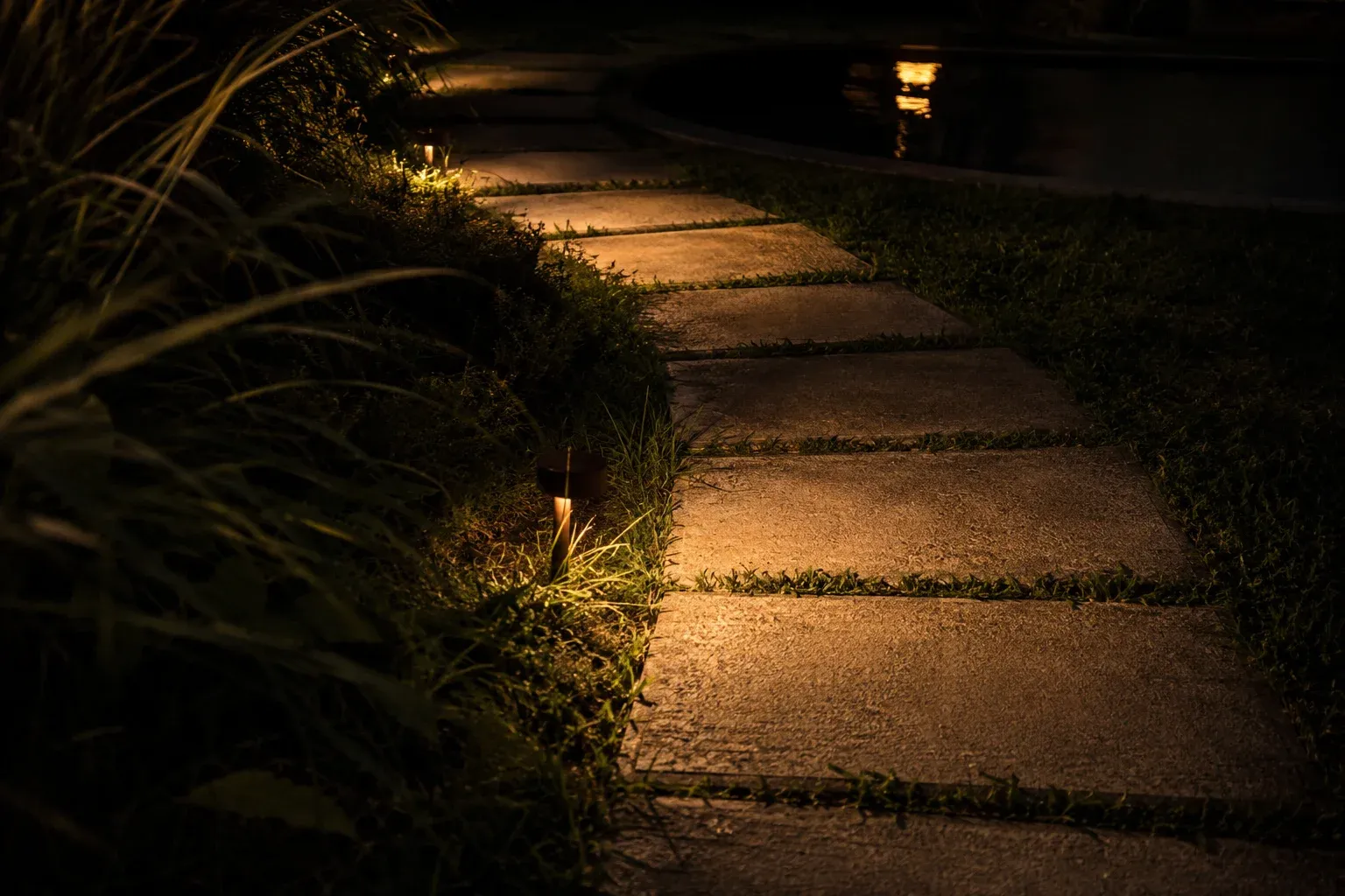 Camino de jardín iluminado a ras del piso.